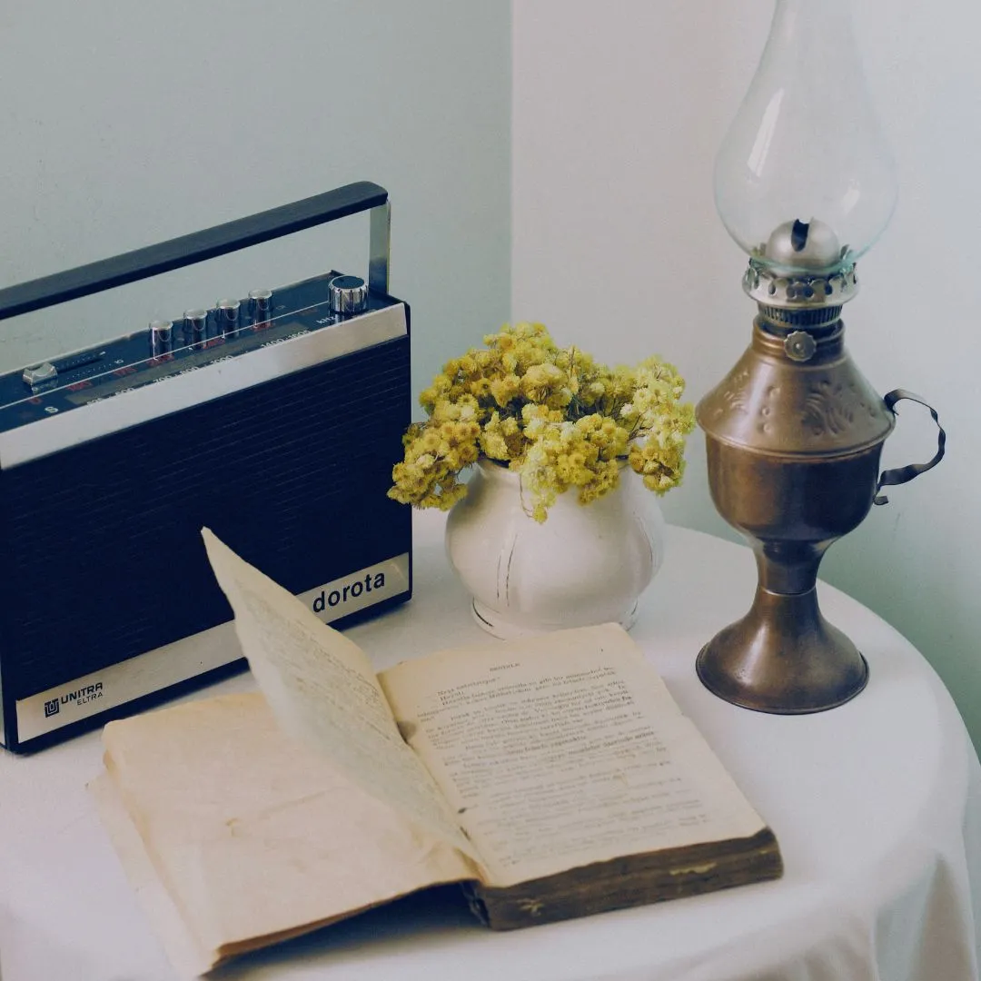 Books and Nostalgia A book with a lantern, a vase, and a radio