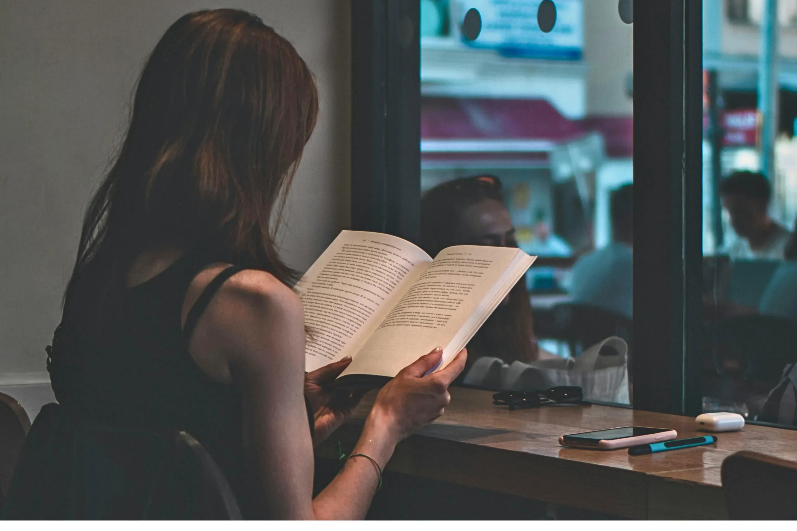 girl reading book in a cafe