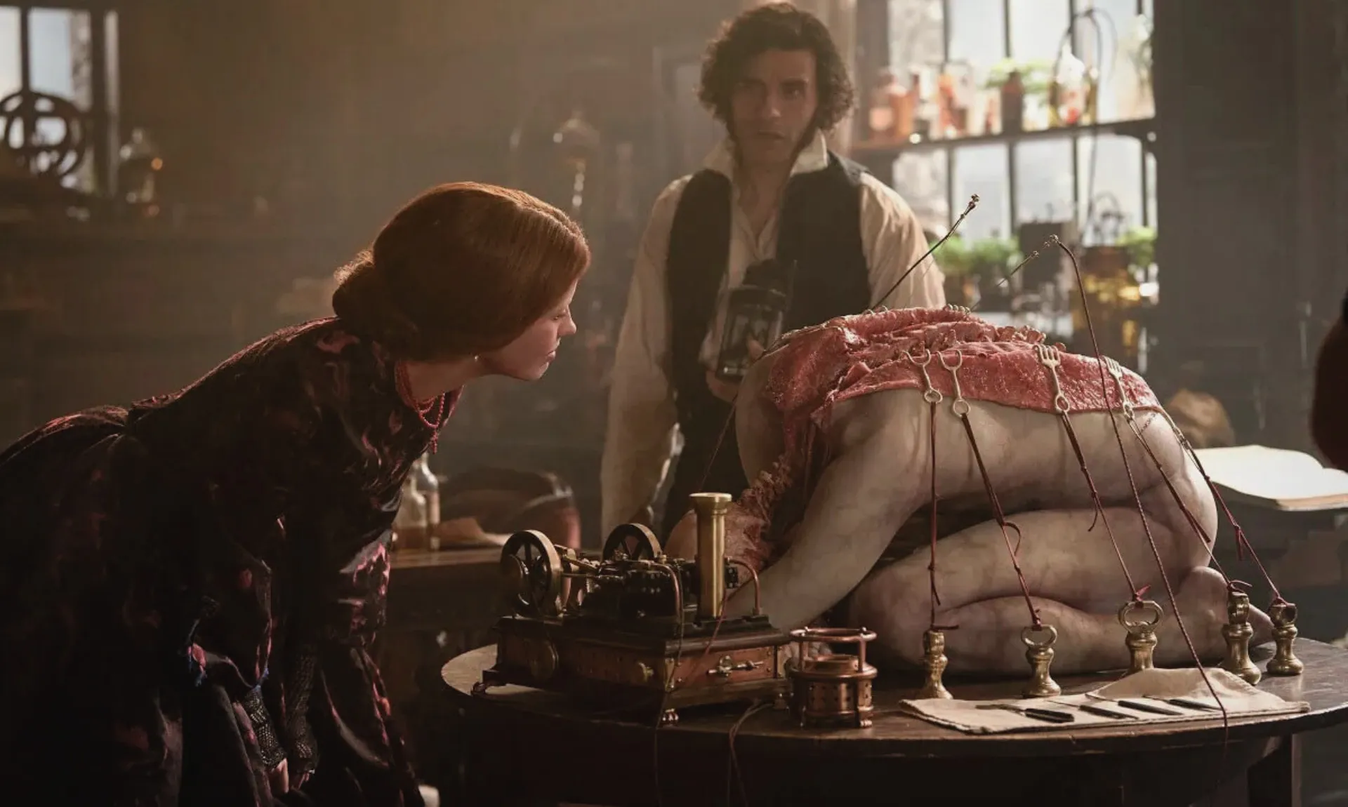 Still from del Toro’s Frankenstein showing the scene of creation with Elizabeth, Victor, and the Creautre