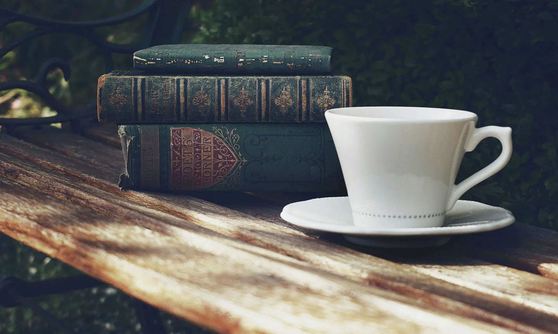 a stack of classic literature books with a cup of tea