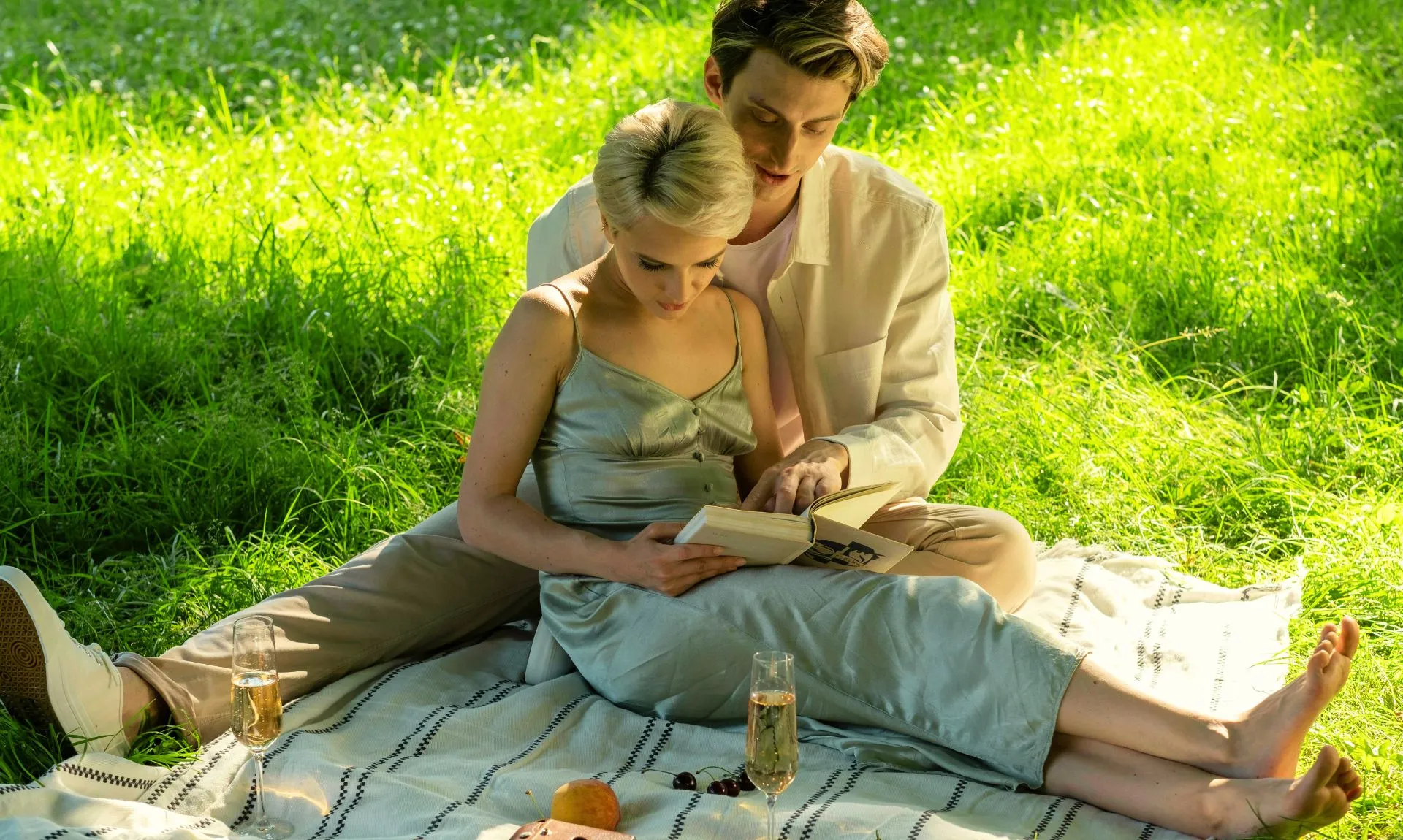 a couple sitting in tree shade reading the best romance books for adults