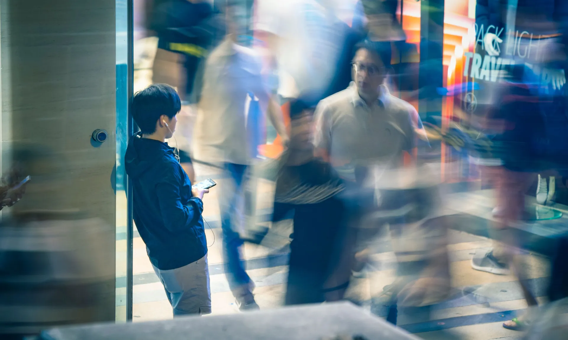 a boy stading alone in a busy crowd
