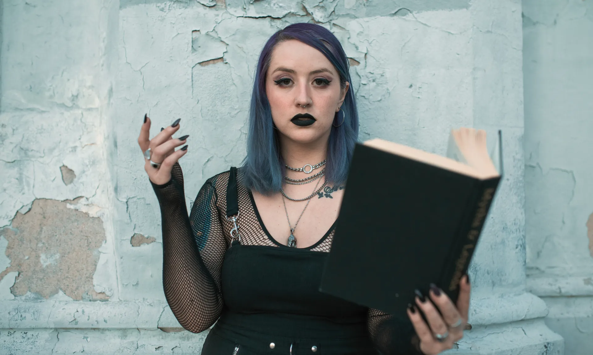 A girl in black top holding a book represeting dark psychological thrillers