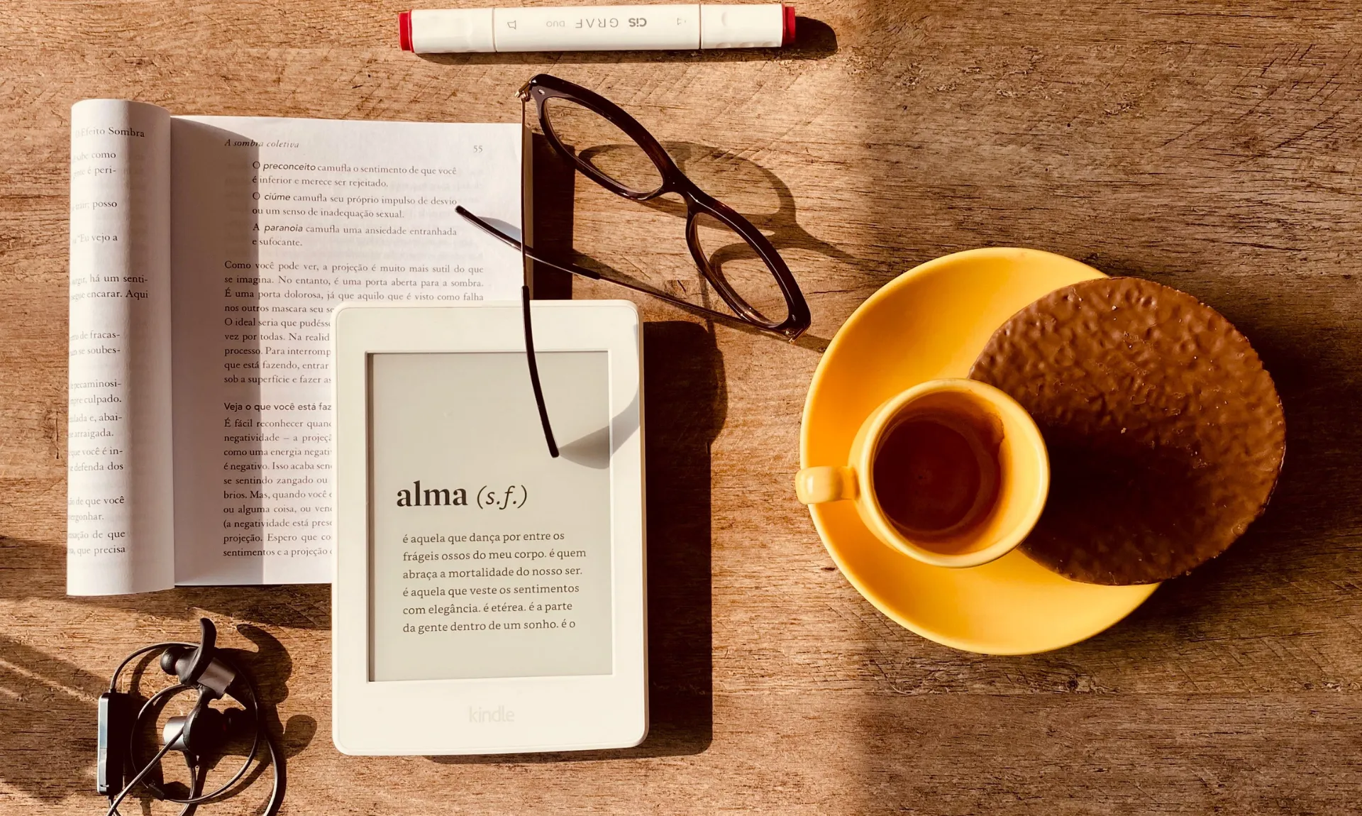kindle and book with a cup of coffee