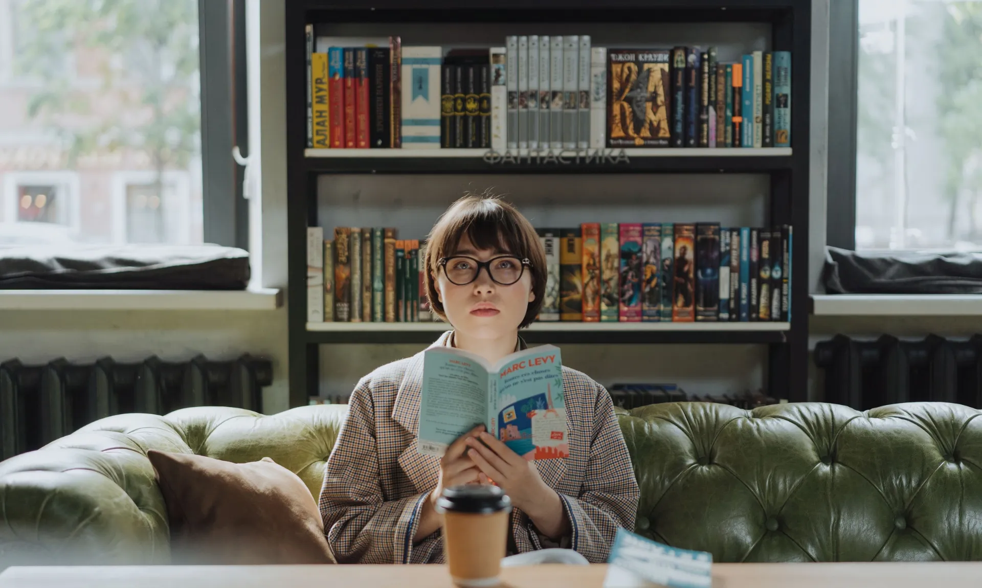girl-reading-in-library a girl sitting on couch with a book in hand